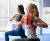 Deux femmes faisant du sport en salle avec un ballon lesté.